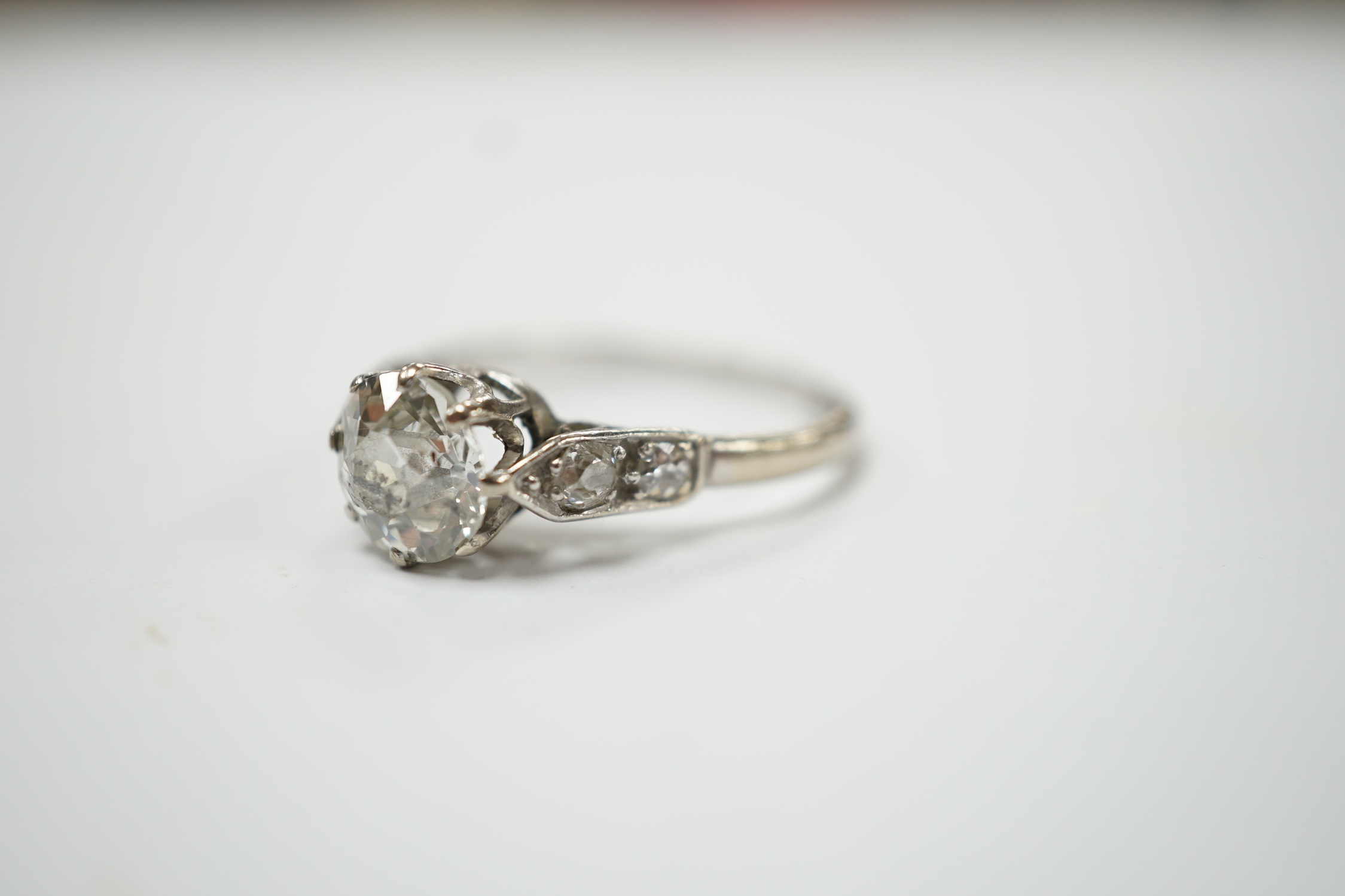 An 18ct, plat. and single stone diamond set ring, with four stone diamond set shoulders, size R/S, gross weight 3.4 grams. Poor condition.